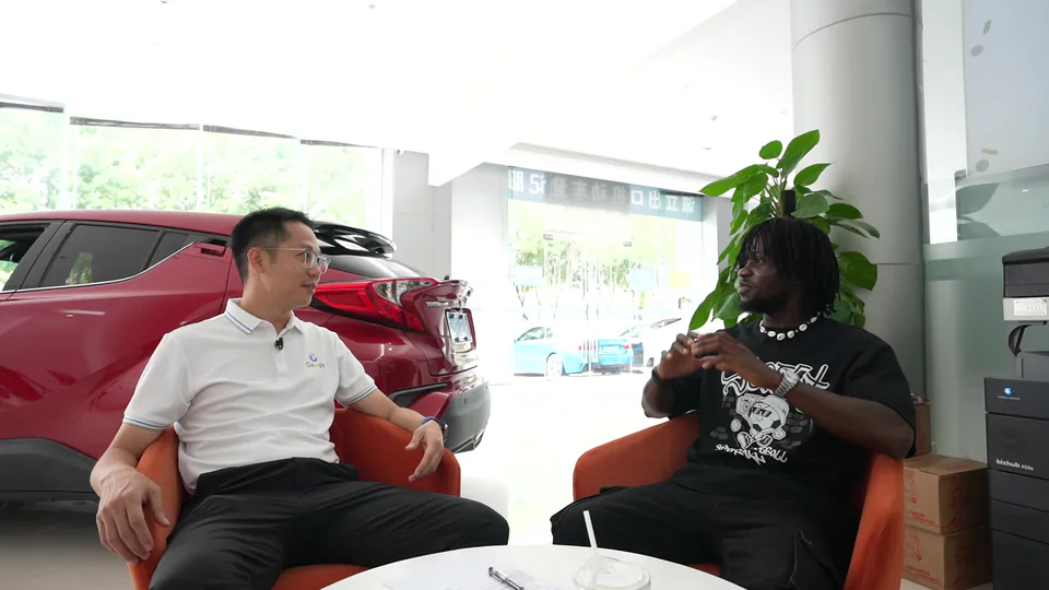 A face-to-face conversation beside showroom vehicles