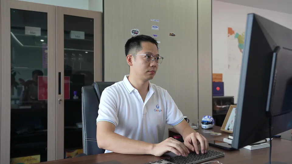 Daniel Liu working at a computer in the office