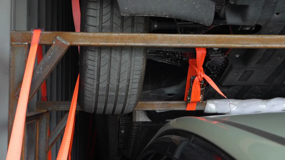 Vehicle rack, tyre and securing straps inside a container