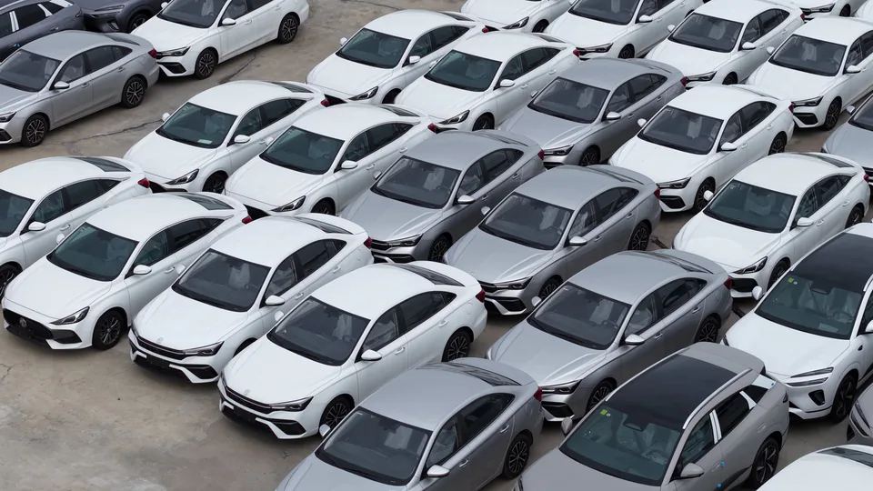 White vehicles arranged in rows, seen from above