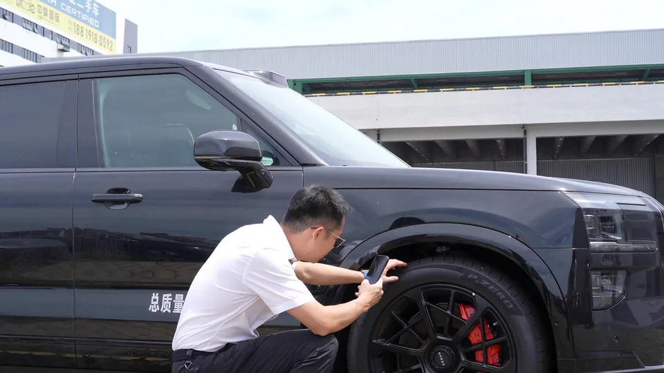 A team member photographing a vehicle wheel