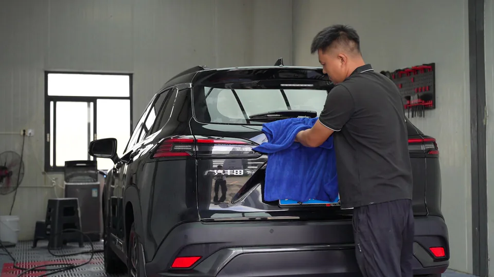 A worker cleaning and preparing a vehicle